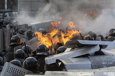 Interior Ministry members are on fire as they stand guard during clashes with anti-government protesters in Kiev