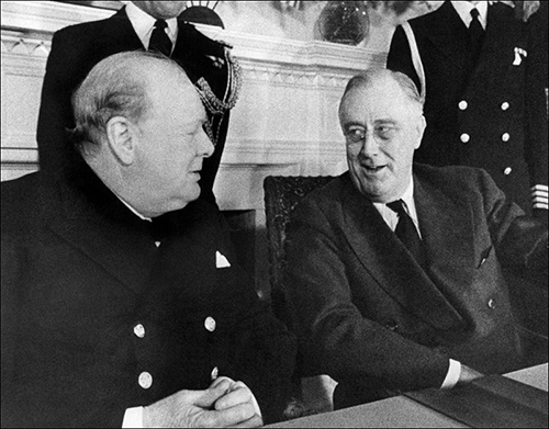 Prime Minister Winston Churchill, left, and President Franklin D. Roosevelt face each other at a conference table in the White House at Washington, Dec. 22, 1941